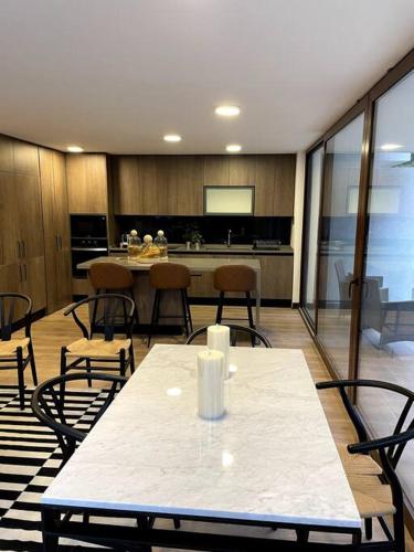 a kitchen with a table and chairs in a room at AT HOME El Golf in Santiago