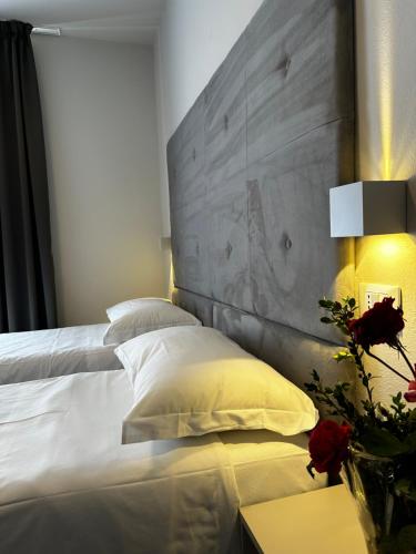 a bedroom with a white bed with a concrete headboard at PFA Hotel - Isola d'Elba in Cavo
