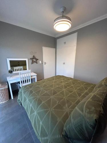 a bedroom with a bed and a desk in it at Blisss in Boggomsbaai