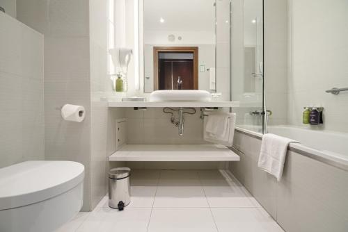 a white bathroom with a sink and a toilet at Qubus Hotel Bydgoszcz in Bydgoszcz