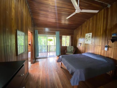 - une chambre avec un lit dans une pièce dotée de murs en bois dans l'établissement Birds & Breakfast Costa Rica, à Fortuna