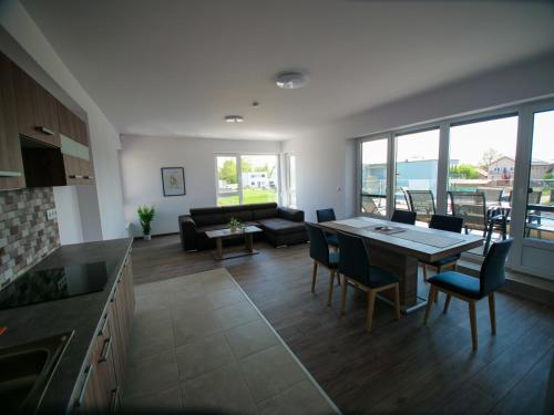 eine Küche und ein Wohnzimmer mit einem Tisch und Stühlen in der Unterkunft Zea Apartmanház in Balatonfenyves