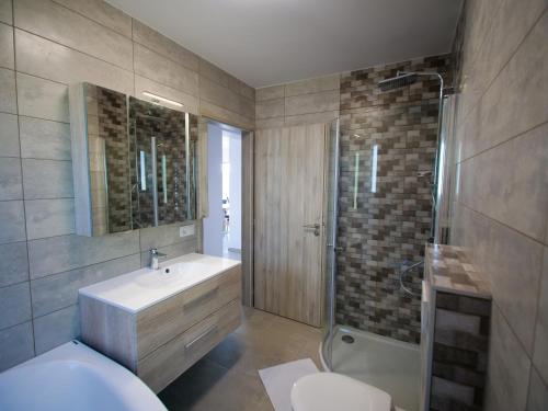 uma casa de banho com um WC, um lavatório e um chuveiro em Zea Apartmanház em Balatonfenyves