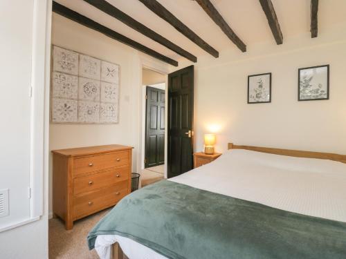 1 dormitorio con cama y tocador de madera en The Cottage en Barrow in Furness