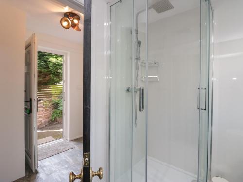 baño con ducha de cristal y puerta de cristal en The Cottage en Barrow in Furness