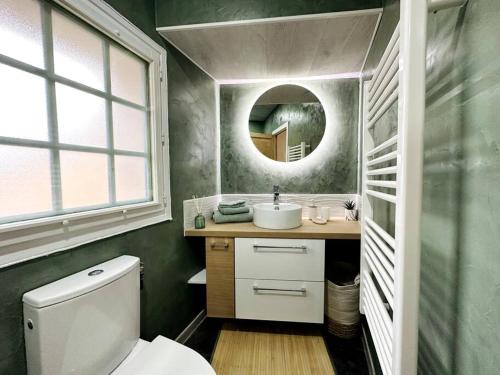 een badkamer met een toilet, een wastafel en een spiegel bij Maison de village sur les chemins de Compostelle in Saint-Gilles