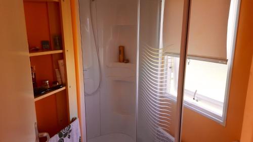 a bathroom with a shower with a toilet and a window at 3 bedrooms bungalow with shared pool furnished balcony and wifi at Pataias 8 km away from the beach in Pataias