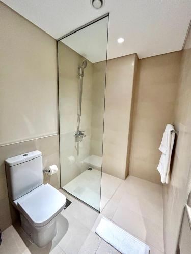 a bathroom with a toilet and a glass shower at The Hive Retreats in Yas Island in Abu Dhabi