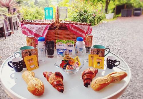 a table with bread and croissants and a basket of food at La Maison au bord du Lac in Chemillé-sur-Indrois