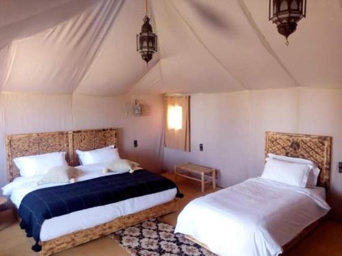 a bedroom with two beds in a room at hello desert camp in Erfoud