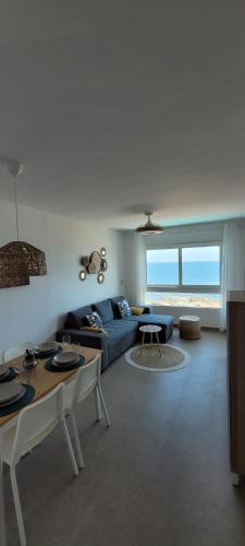 a living room with a blue couch and a table at Beachfront Apartment La Manga in La Manga del Mar Menor