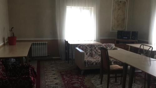 a living room with a table and chairs and a window at Hostel A99 in Astana