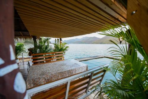 a porch with a bench and a view of the water at Hometown Riverview - โฮมทาวน์ ริเวอร์วิว in Si Sawat