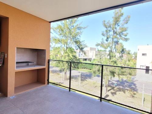 Un balcón con una gran ventana con vistas. en Hermoso departamento con vistas al verde y pileta! en Pilar