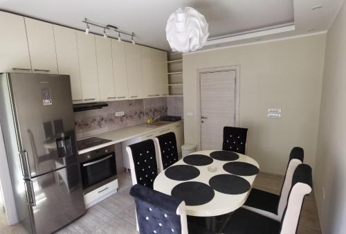 a kitchen with a table and chairs and a refrigerator at Kalina Apartment in Dušanovac (historical)