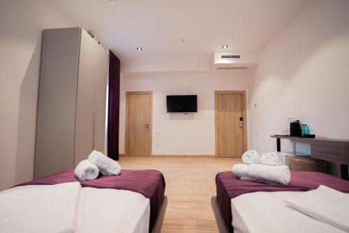 塔什坎的住宿－5 Wood Hotel & SPA，酒店客房设有两张床和一台平面电视。