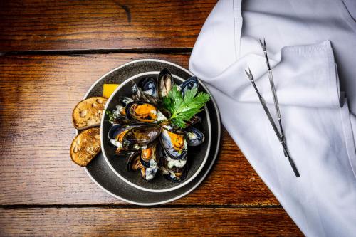 a plate of food with mussels and bread on a table at Skeabost House Hotel in Portree