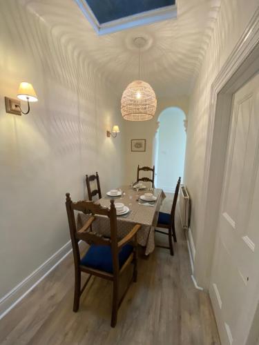 Un comedor con una mesa y sillas y una lámpara de araña. en Peaceful Coastal Apartment, en Ventnor