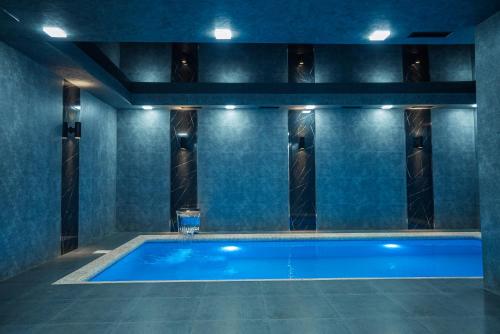 塔什坎的住宿－5 Wood Hotel & SPA，蓝色墙壁的房间内的游泳池