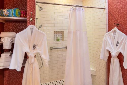 a bathroom with white robes and a shower at Amelia Island Williams House in Fernandina Beach