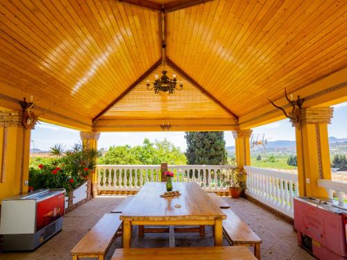 einem Holzpavillon mit einem Holztisch auf der Veranda in der Unterkunft Cubo's Villa Fina & Minigolf included in Málaga