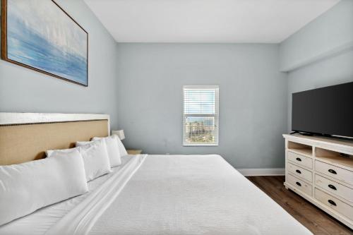 une chambre avec un lit et une télévision à écran plat dans l'établissement Laketown Wharf #2136 by Nautical Properties, à Panama City Beach