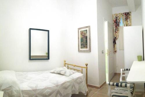 een slaapkamer met een bed en een spiegel aan de muur bij La Ninfea 