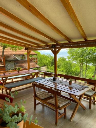 un patio con tavoli e panche in legno su una terrazza di Paradise Nest a Ohrid