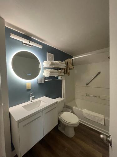 W łazience znajduje się umywalka, toaleta i lustro. w obiekcie Woodland Motel w mieście Salida