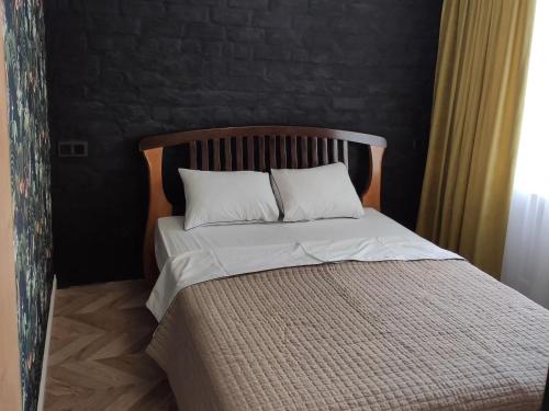 uma cama com duas almofadas brancas num quarto em BotaNika em Kremenchuk