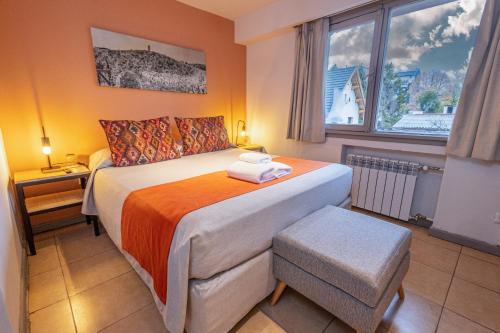 a small bedroom with a bed and a window at Hotel Tierra Gaucha in San Carlos de Bariloche
