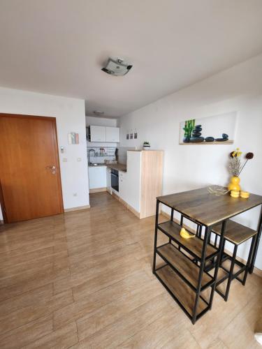 a living room with a table and a kitchen at Lucija in Karlobag