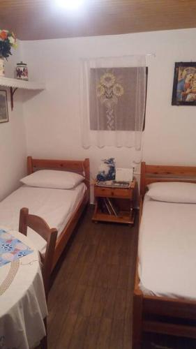 a small room with two beds and a window at Θέα in Kamares
