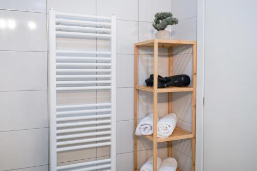 a closet with wooden shelves and towels at Happy apartment Ilidža in Sarajevo