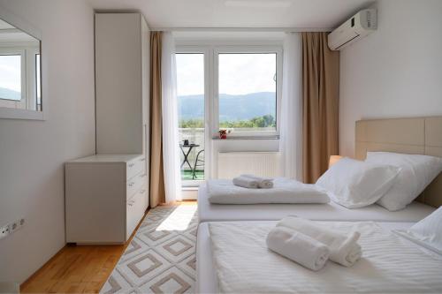 a hotel room with two beds and a window at Happy apartment Ilidža in Sarajevo