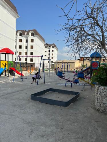 an empty playground with swings and a kid on a swing at Comfortable 2-roomed apartment Ozod Apartments SU2 in Samarkand