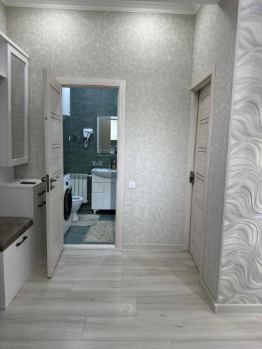 a bathroom with a toilet and a sink and a door at Comfortable 2-roomed apartment Ozod Apartments SU2 in Samarkand