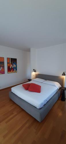 een slaapkamer met een bed met twee rode kussens erop bij IseoLakeRental - Vacanza Romantica in Riva di Solto