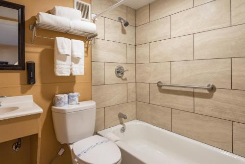 a bathroom with a toilet and a tub and a sink at Town Motel in Forks