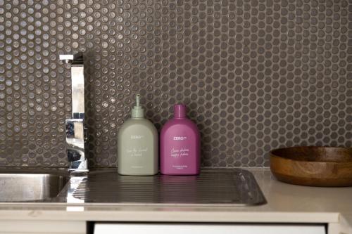 two bottles of soap sitting on top of a sink at Kahlo Alexandria - Stylish 2 bdrm Walk to Train in Sydney