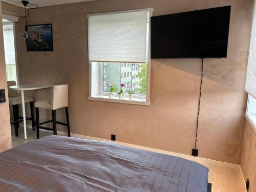 - une chambre avec un lit et une télévision à écran plat dans l'établissement MK8 Apartment, à Bergen