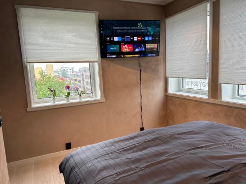 1 dormitorio con 2 ventanas y 1 cama. en MK8 Apartment en Bergen