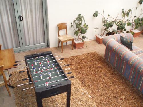 a living room with a foosball table on a rug at Fernhill Motor Lodge in Lower Hutt