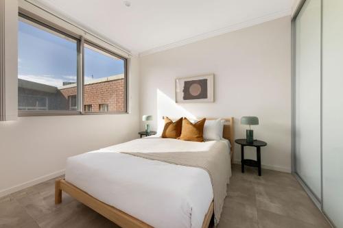 a bedroom with a bed and a large window at Kahlo Alexandria - Stylish 2 bdrm Walk to Train in Sydney