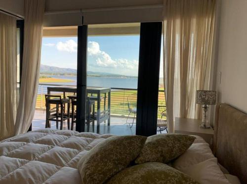 a bedroom with a bed and a view of the ocean at Gran Depto 2dorm Los Molinos PREVIAJE in Villa General Belgrano