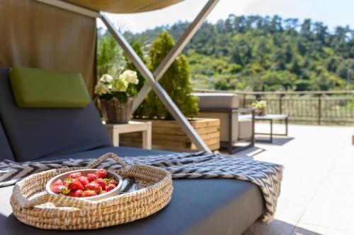 a bowl of strawberries on a table on a balcony at Nikoleta Hotel and Villas in Limenas