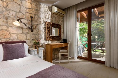 a bedroom with a bed and a stone wall at Nikoleta Luxury Villa in Limenas
