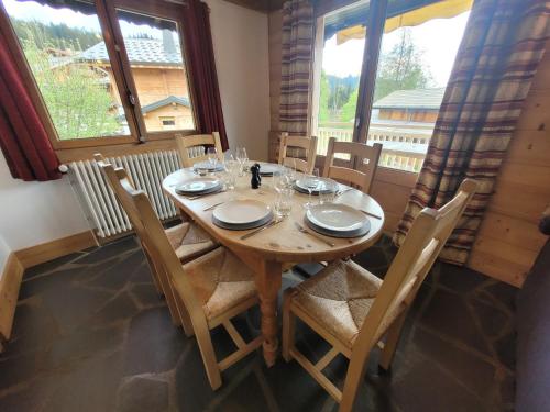 une salle à manger avec une table et des chaises en bois dans l'établissement Chalet familial aux Gets, proche pistes, 4 chambres, cheminée et Wifi - FR-1-598-35, aux Gets