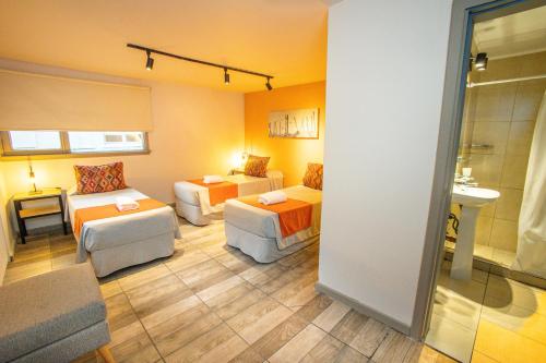 Habitación con 2 camas y sala de estar. en Hotel Tierra Gaucha en San Carlos de Bariloche