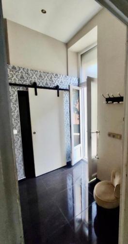 une pièce avec une porte blanche et un tabouret dans une pièce dans l'établissement CANNES t4 bourgeois 790M de la plage, Palais et Croisette, à Cannes